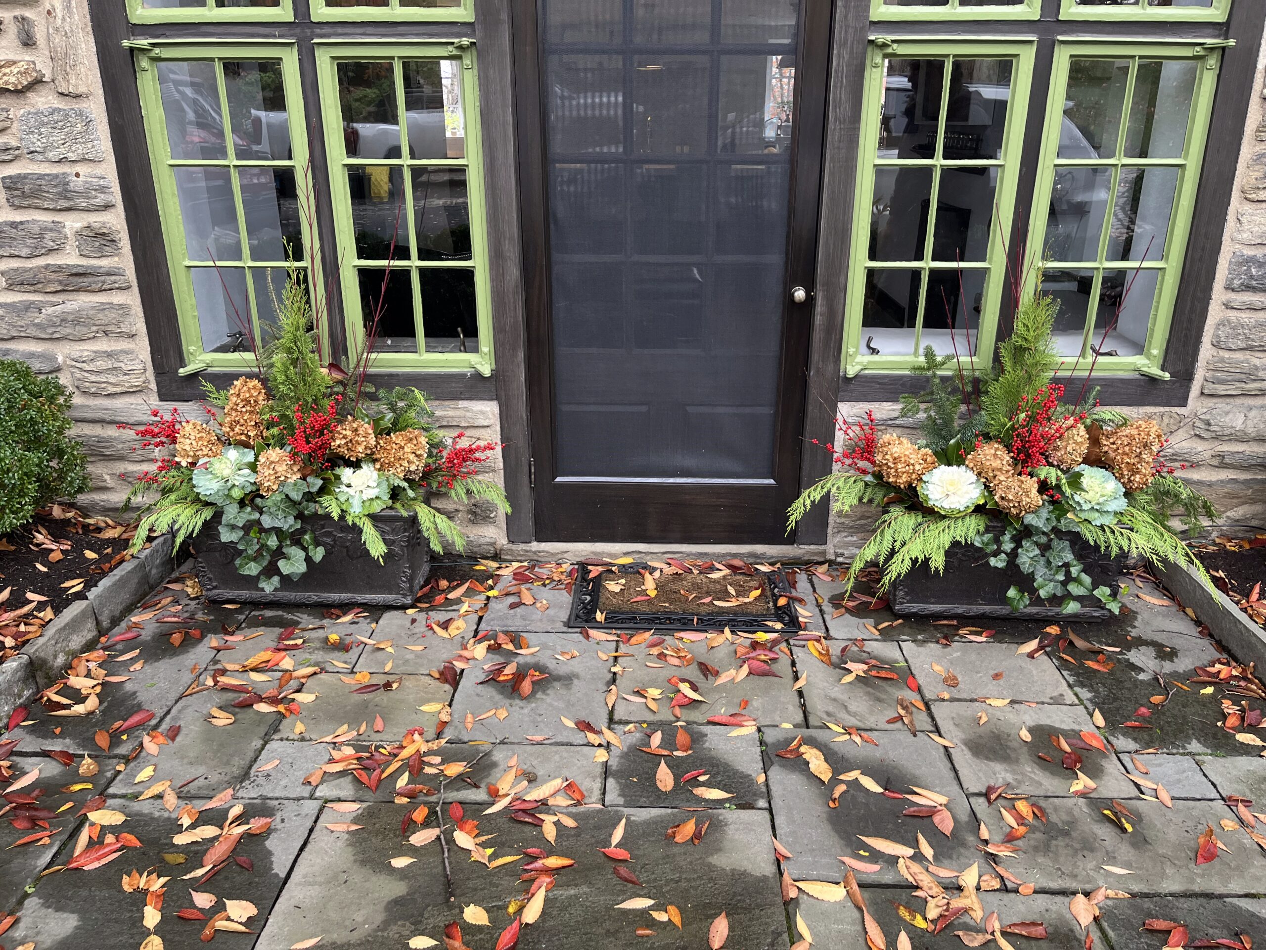 Autumn leaves and floral arrangements at doorsteps.