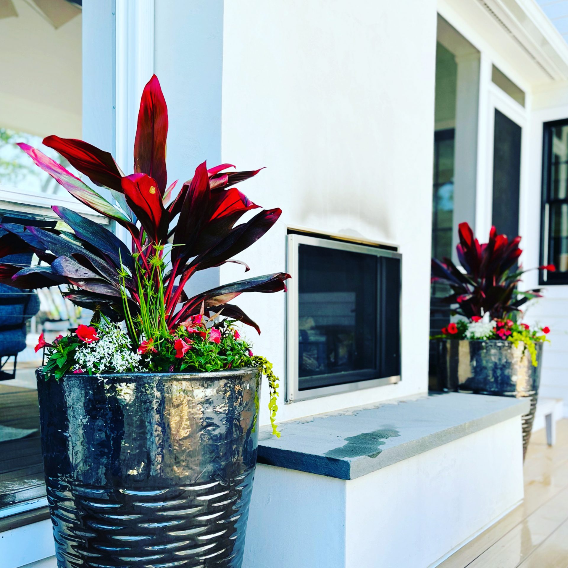 Decorative potted plants beside outdoor fireplace
