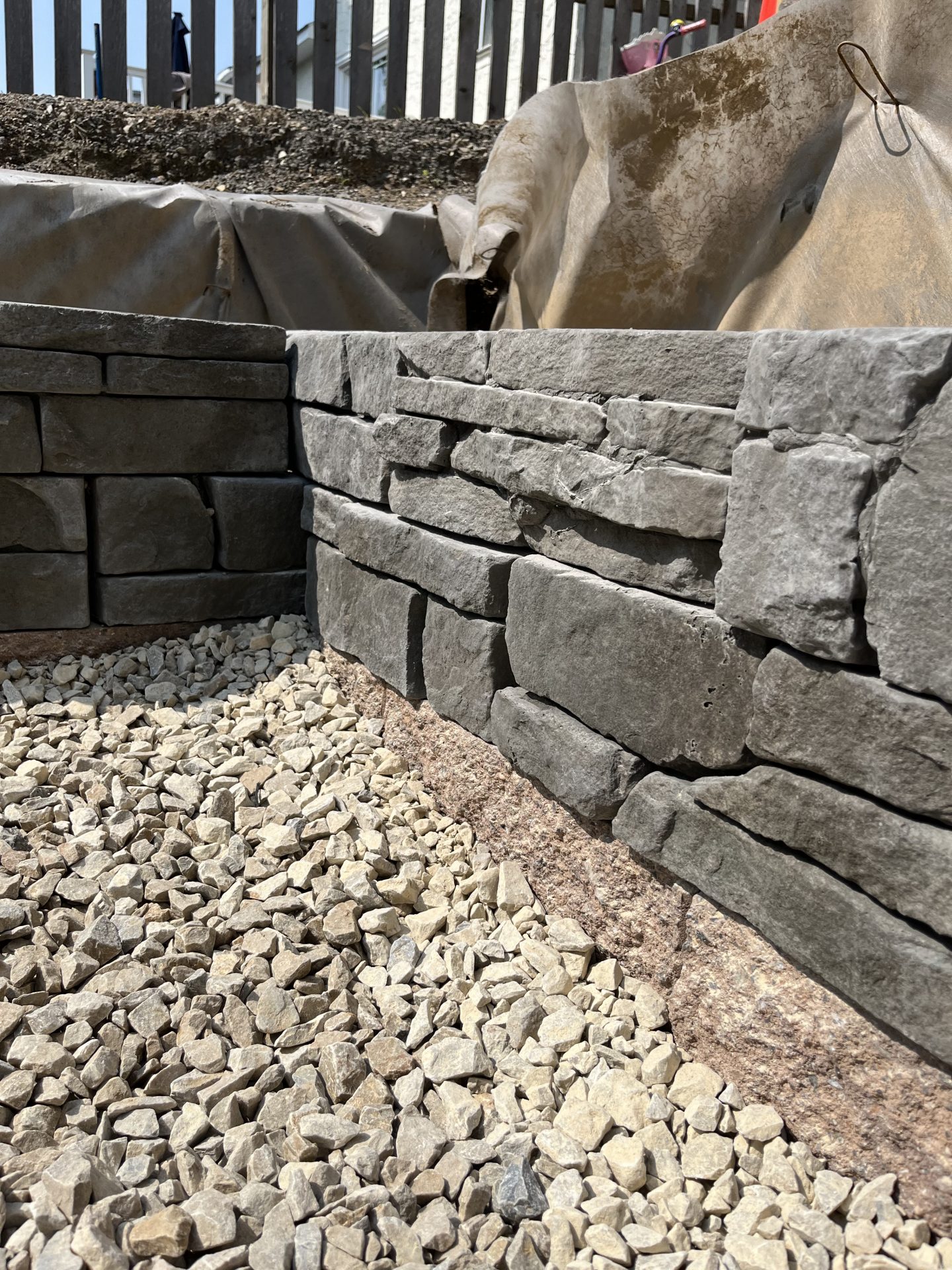 Close-up of stone retaining wall with gravel base.