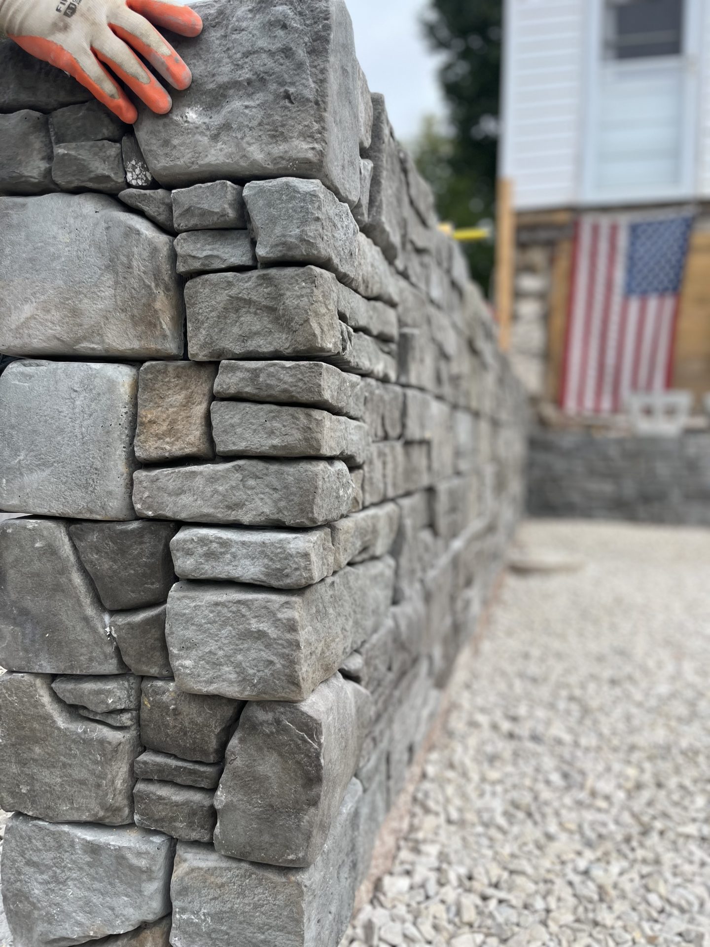 Close-up of stone wall with gloved hand.
