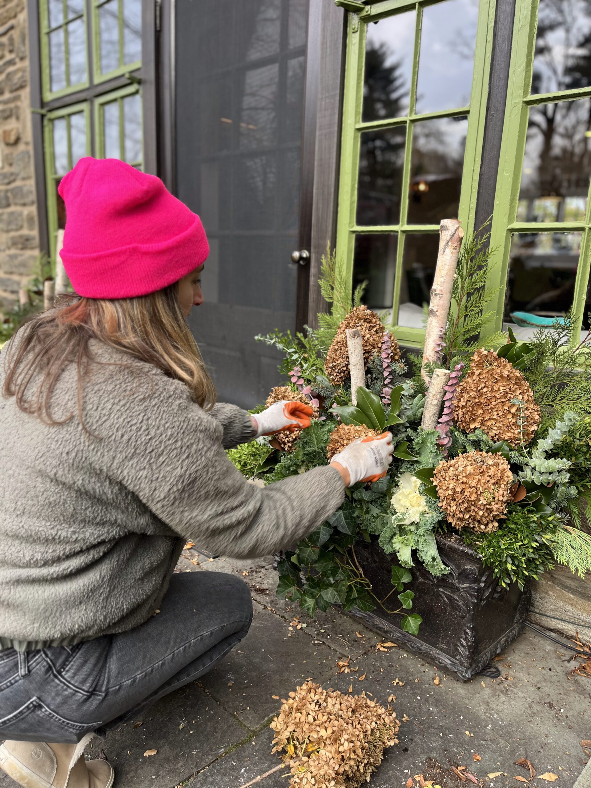 Woman arranging flowers in outdoor planter