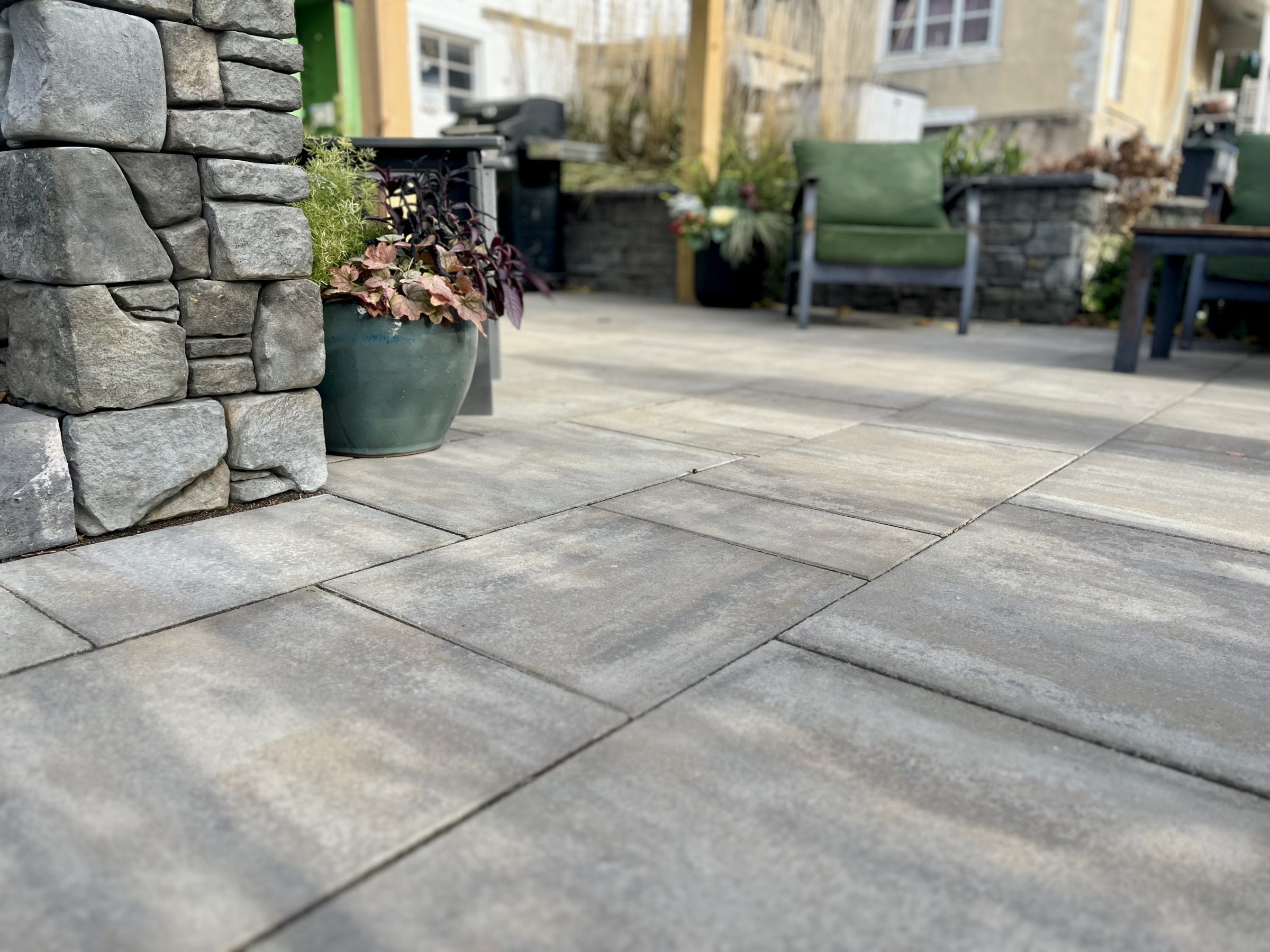 Stone patio with plants and seating area.