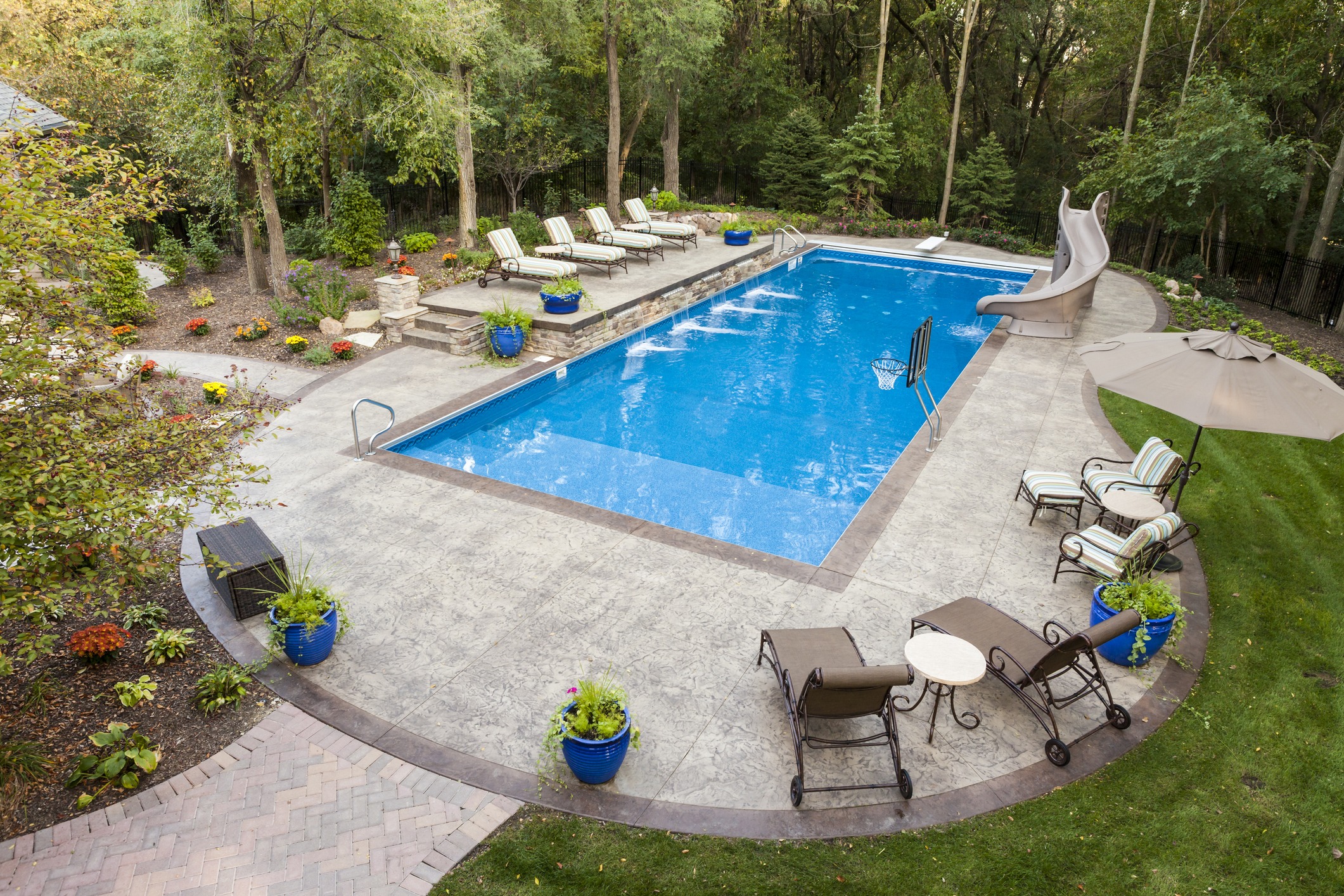 Backyard pool with slide and seating area.