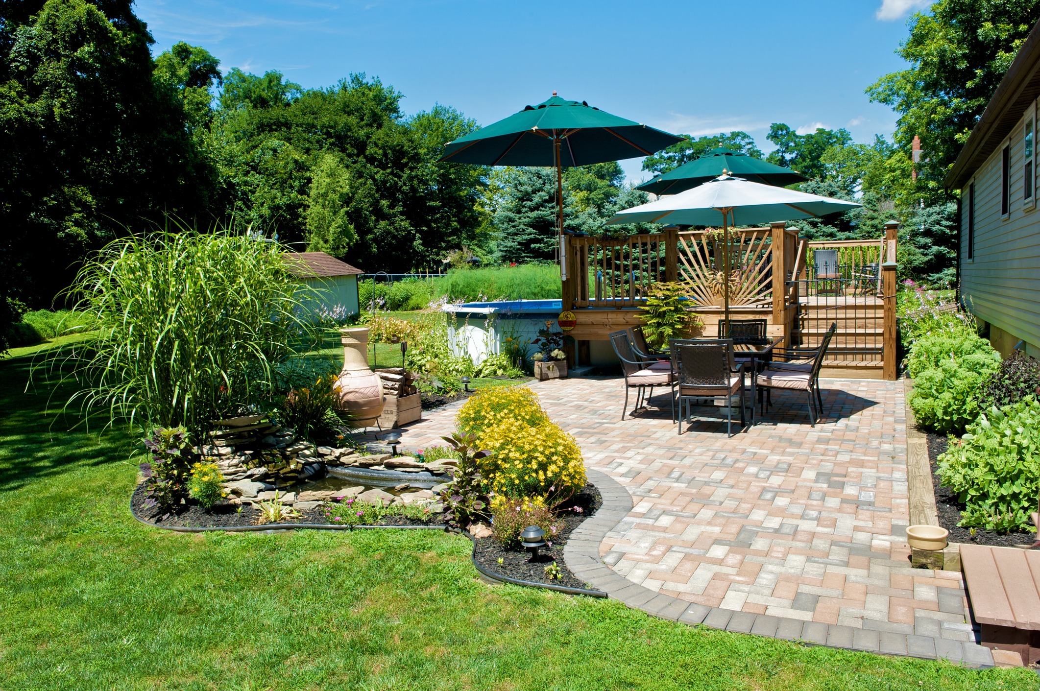 Backyard patio with garden, pavers, and seating area.