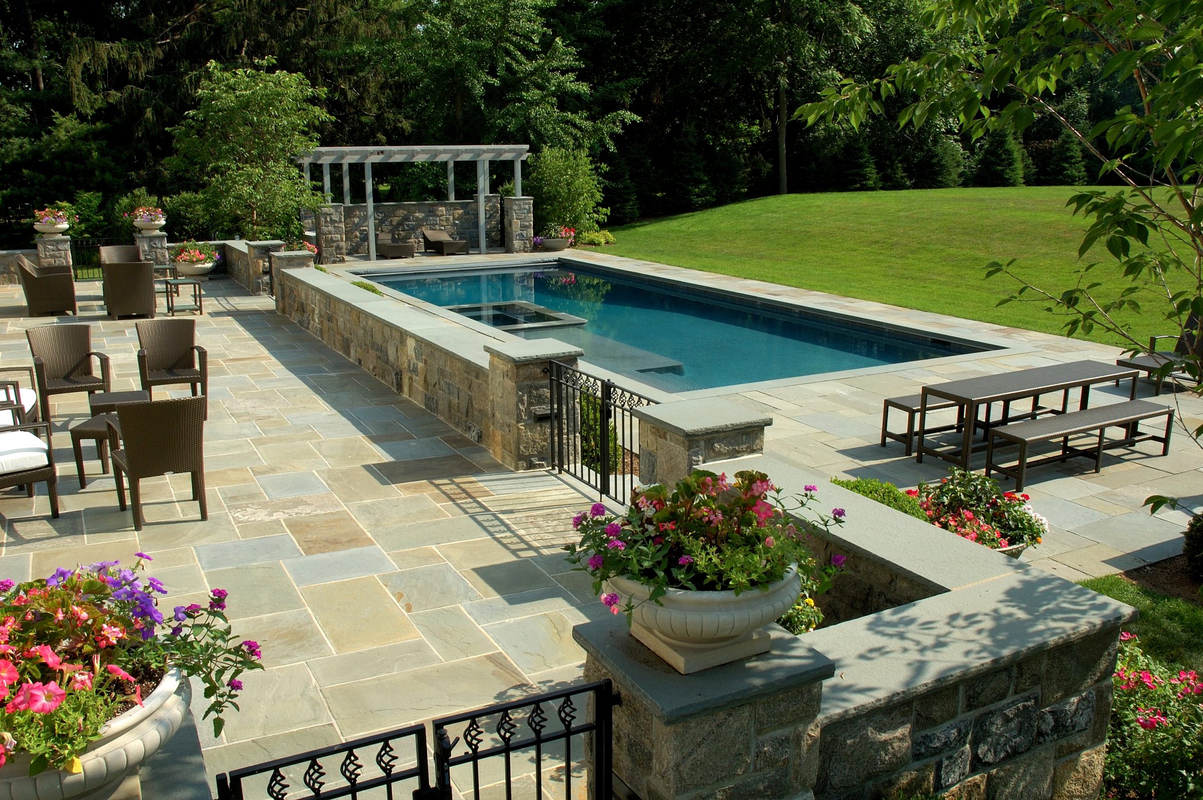 Elegant backyard pool with patio and garden seating.